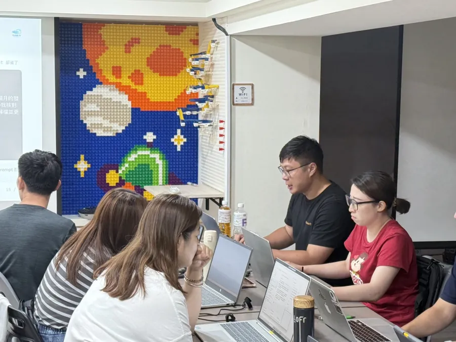 Alex 在企業內訓教室座位旁，與學員一對一討論操作問題